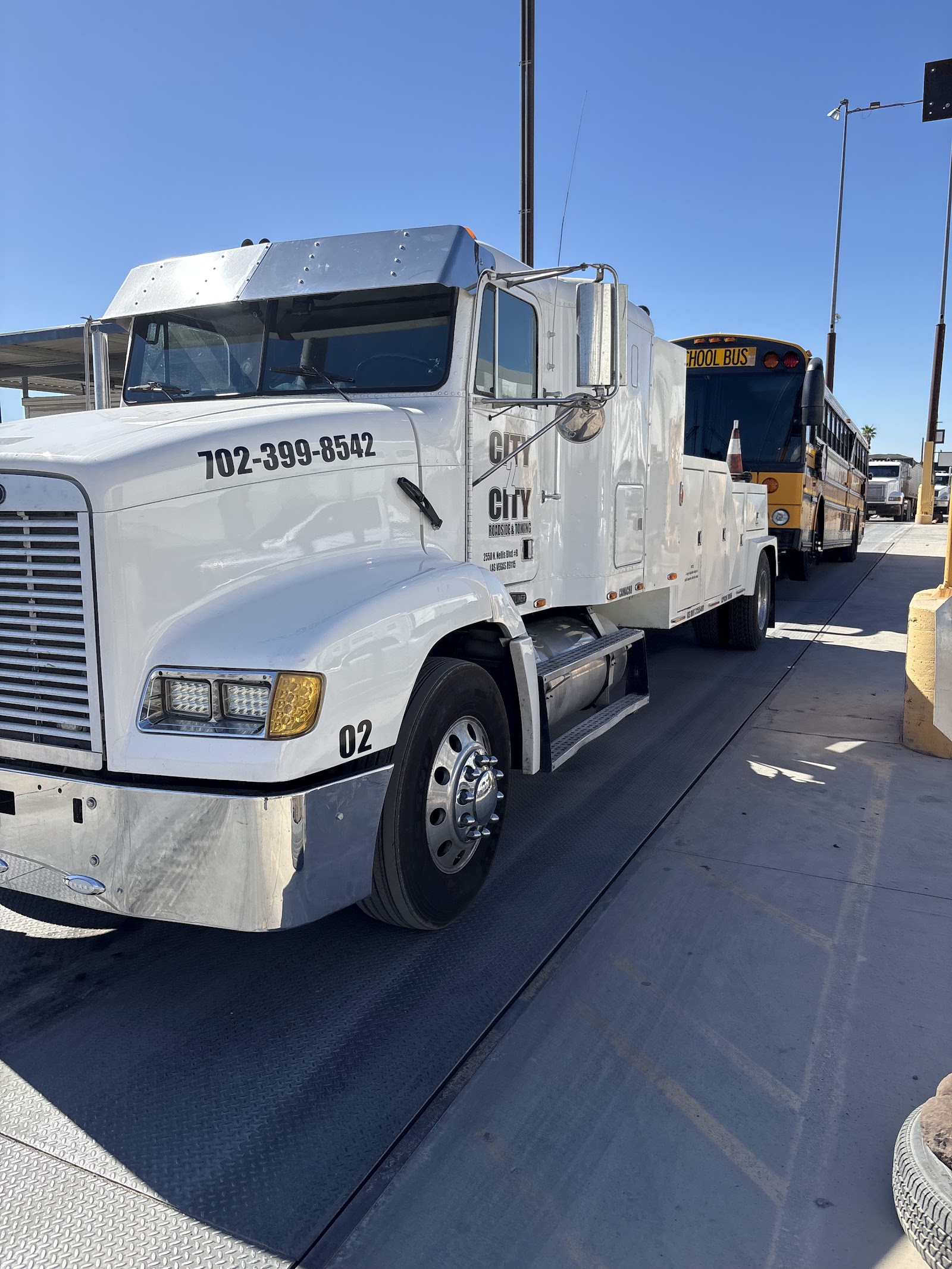 City 2 City white heavy-duty tow truck parked, phone number 702-399-8542 visible