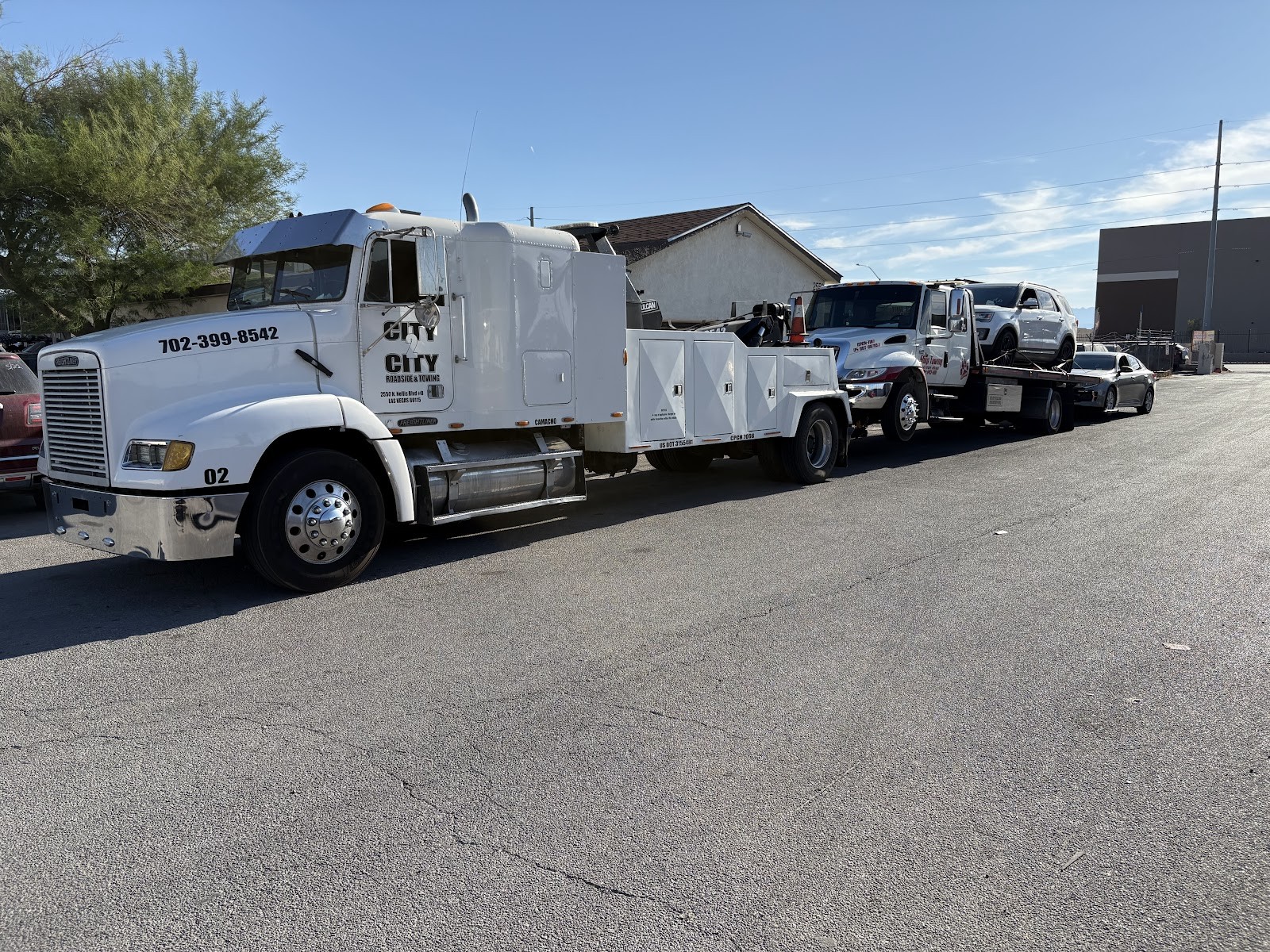 City 2 City tow trucks with a vehicle loaded on a flatbed rollback